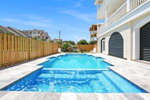 a swimming pool in a backyard with a wooden fence at Beach Haven in North Litchfield Beach