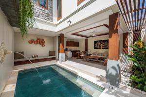 einen Innenpool in einer Villa mit einem Wohnzimmer in der Unterkunft Tanadewa Villas Nusa Dua Bali by Cross Collection in Nusa Dua