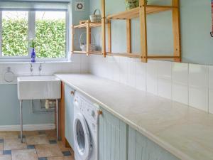 a kitchen with a washing machine and a sink at Meadow View in Hockering
