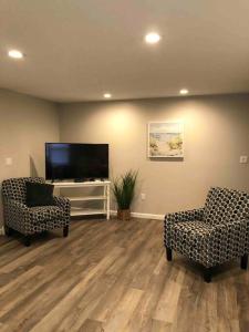 a living room with two chairs and a flat screen tv at Spacious Home near Airport in Bangor