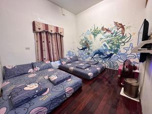 uma sala de estar com uma cama e um sofá em Instructor 818 Rooms Homestay em Xiaoliuqiu