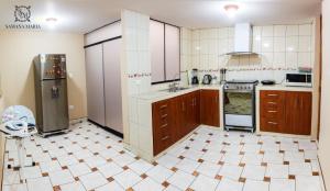 a large kitchen with brown cabinets and a tile floor at SSAMANA MARÍA APARTMENT 102 in Arequipa