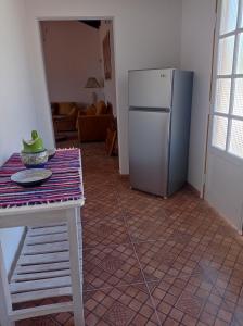 a kitchen with a table and a refrigerator at Casa de la Amistad in Areguá