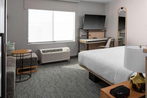 TownePlace Suites by Marriott Buckeye Verrado في باكاي: غرفة نوم بسرير ومكتب وتلفزيون