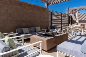 een patio met stoelen, een bank en tafels bij TownePlace Suites by Marriott Buckeye Verrado in Buckeye