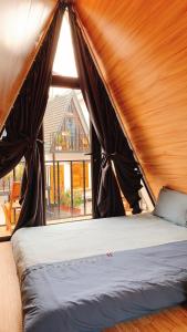 a bed in a tent with a large window at CuDen Homestay Venuestay in Vĩnh Phúc