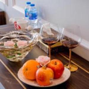 Deux verres de vin et quelques tomates sur une table dans l'établissement Sophia Hotel, à Hai Phong