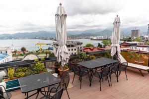 a balcony with tables and chairs and a view of the water at Hotel Old Town in Batumi