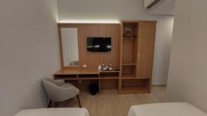 Camera con scrivania, TV e specchio. di AYMAN SYARIAH HOTEL a Surabaya