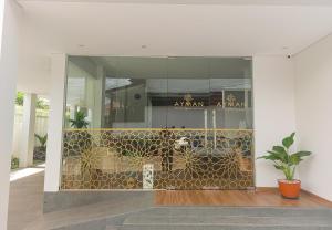 um edifício com um átrio com uma parede de vidro em AYMAN SYARIAH HOTEL em Surabaia