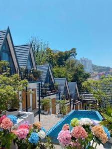 a house with a swimming pool and some flowers at CuDen Homestay Venuestay in Vĩnh Phúc