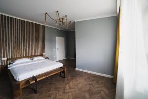 1 dormitorio con cama y lámpara de araña en Voronet Noir Chalet, en Voroneț