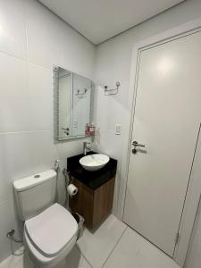 a white bathroom with a toilet and a sink at 2 Dormitorios Edificio Zetta Village Airport in Colonia Mariano Roque Alonso