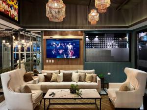 a living room with a couch and chairs and a tv at 2 Dormitorios Edificio Zetta Village Airport in Colonia Mariano Roque Alonso