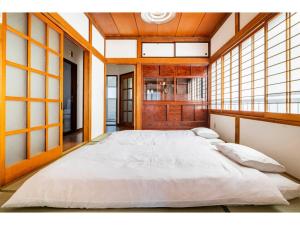 a large white bed in a room with windows at Nikko Main Street House - Vacation STAY 04324v in Nikko