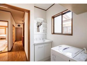 y baño con lavabo y lavadora. en Nikko Main Street House - Vacation STAY 04324v en Nikko