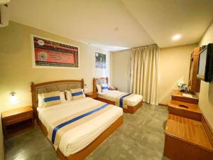 a hotel room with two beds and a television at Aladdin Dream Hotel in Johor Bahru