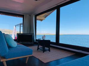 uma sala de estar com vista para a água em Titicaca island lodge peru em Puno