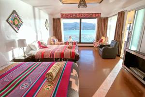 uma sala de estar com duas camas e vista para o oceano em Titicaca island lodge peru em Puno