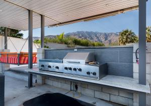 a grill on a patio with a view of the mountains at Luxury Desert Oasis in Palm Springs