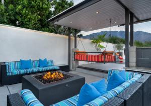 a patio with blue chairs and a fire pit at Luxury Desert Oasis in Palm Springs