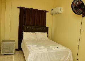 a bedroom with a bed with two towels on it at Hotel Freedom Nagua in Nagua