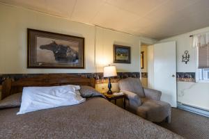 ein Schlafzimmer mit einem Bett und einem Stuhl in der Unterkunft Sunset RV Park and Motel in Belle Fourche