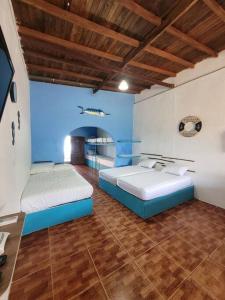 Habitación con 2 camas, paredes azules y techos de madera. en fantástica habitación frente al mar 103, en San Silvestre