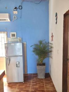 cocina azul con nevera y maceta en fantástica habitación frente al mar 103, en San Silvestre