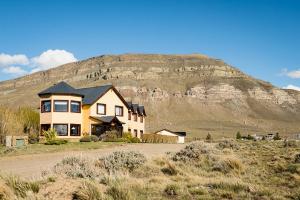 ein Haus mit einem Berg im Hintergrund in der Unterkunft Hosteria Roblesur in El Calafate