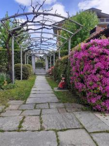 a garden with pink flowers and a greenhouse at CASA MICHELA BB OSSOLA PARKING FREE in Domodossola