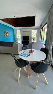 Kluai Mai Luxury Pool Villa, Panorama Resort في هوا هين: غرفة معيشة مع طاولة وكراسي بيضاء