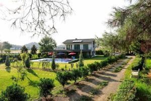 a garden with a house and a swimming pool at Narya, Peaceful Farmhouse in the Forest in Koycegiz