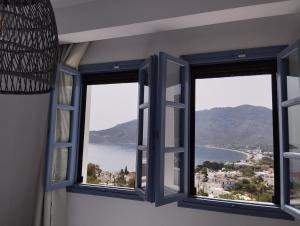 Zimmer mit 3 Fenstern und Blick auf das Wasser in der Unterkunft THALASSA in Livadia