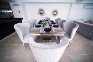 a dining room with a table and white chairs at luxury suite presidencial 