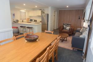 Una cocina y una sala de estar con una mesa y sillas de madera. en Discobolus 2 AMS Mt Buller, en Mount Buller