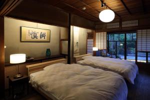 舞鶴市にある古民家の宿宰嘉庵 TraditionalJapaniseHotel Saikaanのランプ2つ付きの部屋のベッド2台