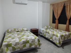 a bedroom with two beds and a window at Casa D'Lucas in Puerto Baquerizo Moreno