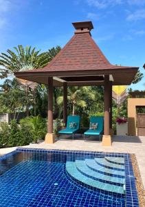 cenador con 2 sillas y piscina en Kluai Mai Luxury Pool Villa, Panorama Resort, en Hua Hin