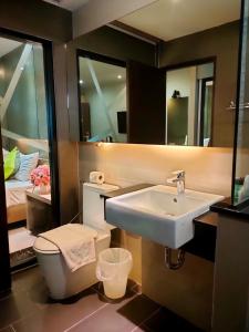 ein Badezimmer mit einem Waschbecken, einem WC und einem Spiegel in der Unterkunft 3Season in Chiang Mai