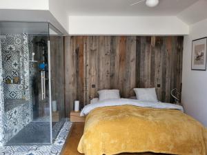 a bedroom with a bed and a glass shower at Maison atypique terrasse 3 chambres in Batz-sur-Mer