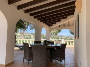 Nice villa in Moraira with private pool and lots of privacy في مورايرا: غرفة طعام مع طاولة وكراسي على الفناء