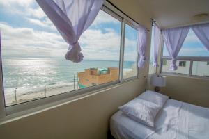 a bedroom with a window with a view of the ocean at Ocean-VIEW Two Story Condo on the beach in Tijuana