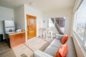 ein Wohnzimmer mit einem grauen Sofa und einer Küche in der Unterkunft Ocean-VIEW Two Story Condo on the beach in Tijuana
