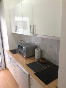 a kitchen with a counter top with a microwave at Coracão Atlantico Beach House in São Roque