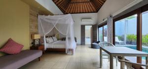 ein Schlafzimmer mit einem Bett, einem Tisch und einer Couch in der Unterkunft Zoe Villa Canggu Bali in Canggu