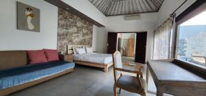 ein Schlafzimmer mit einem Bett, einer Couch und einem Tisch in der Unterkunft Zoe Villa Canggu Bali in Canggu