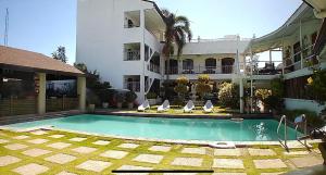 a hotel with a swimming pool in front of a building at Ettamogah Hotel Inc. in Malino