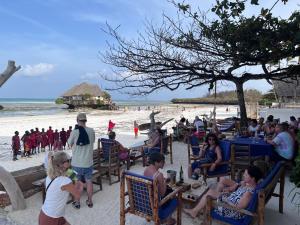 a group of people sitting in chairs on the beach at The View of Zanzibar in Michamvi