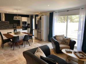 un salon avec un canapé et une salle à manger dans l'établissement Villa les Romarins, à Saint-Didier